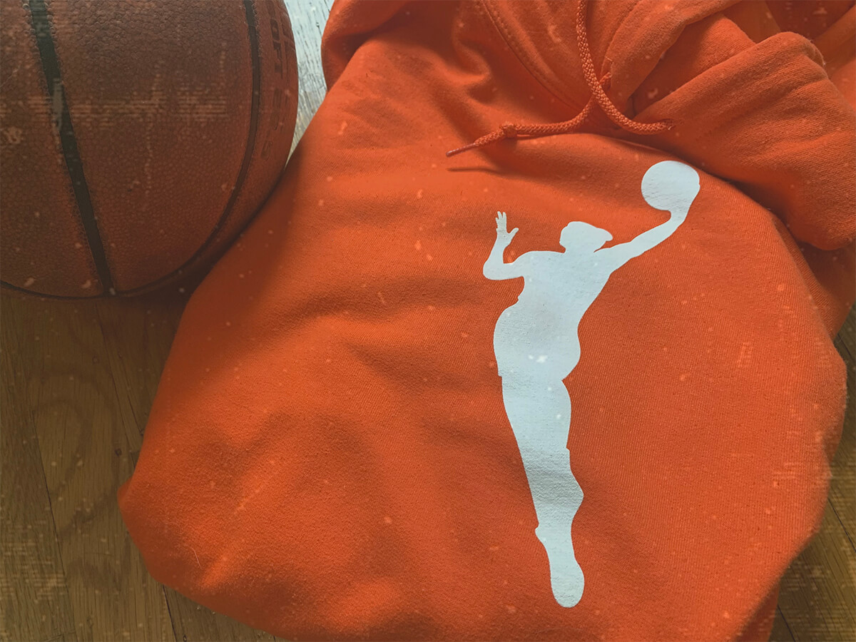 An orange WNBA hoodie with the latest WNBA logo.